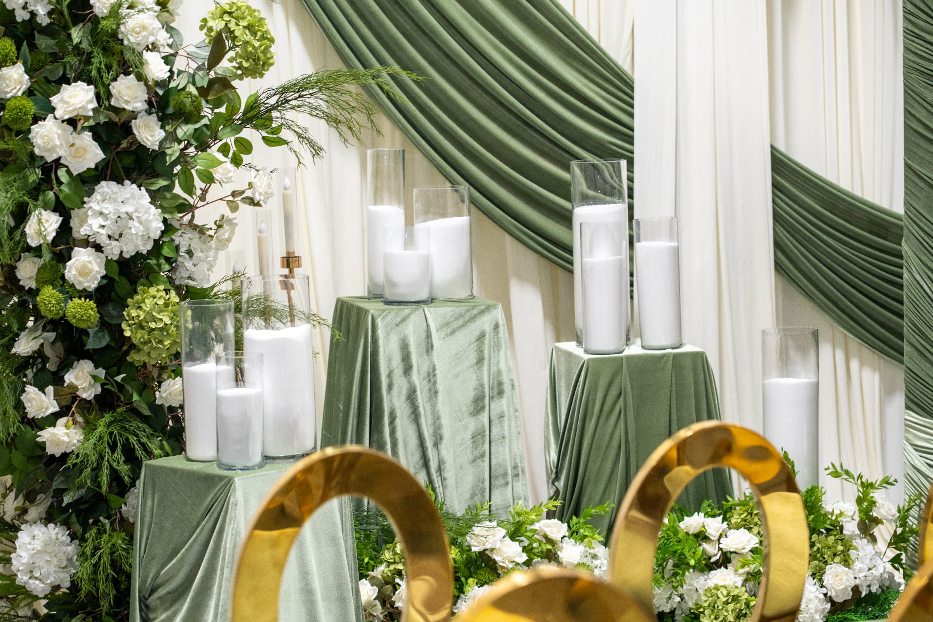 Velvet draped pedestals with pillar candles and white hydrangea details