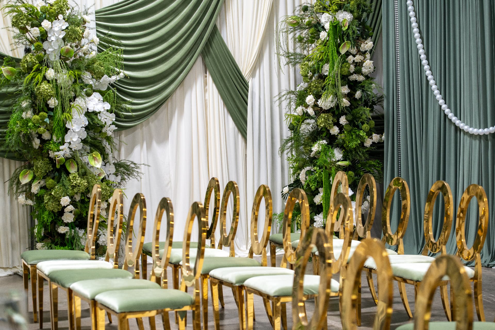 Sage and ivory draping with pearl swags and towering white and green florals