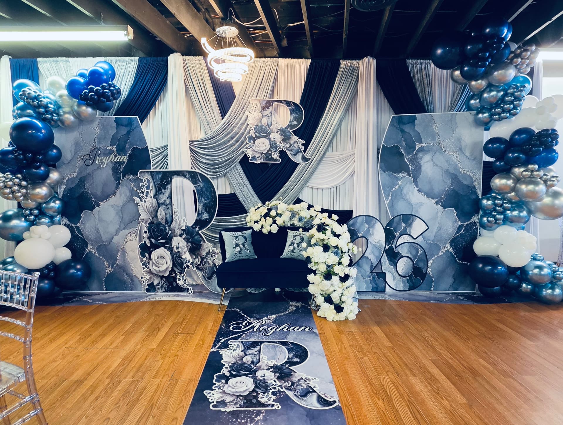 Blue marble prom send-off backdrop with silver and navy balloons and custom aisle runner
