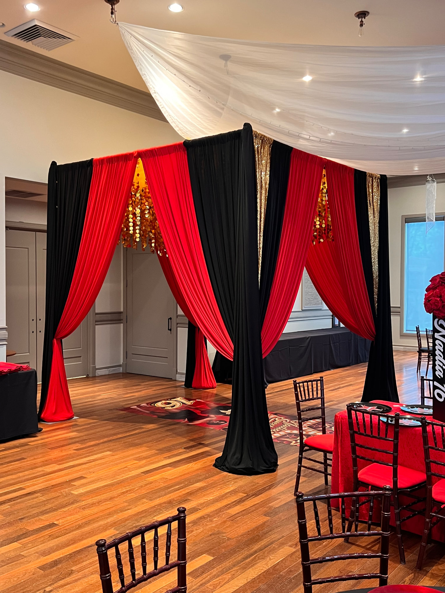 Red, black and gold sequin draped entrance cabana with ceiling swag